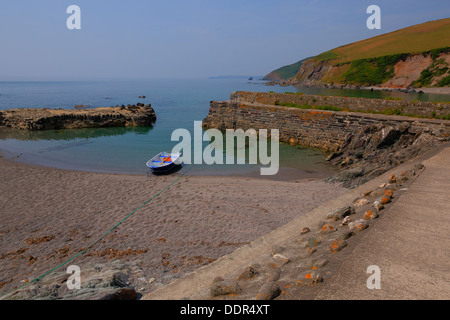 Boat in tiny harbour with green sea in Portwrinkle Cornwall England with deep rich colour in HDR Stock Photo