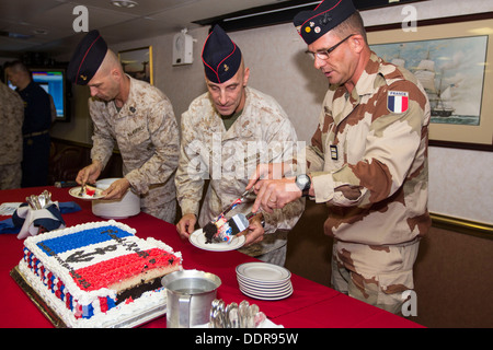 U.S. Marine Corps Col. Matthew G. St. Clair, center, commanding officer of the 26th Marine Expeditionary Unit (MEU), cuts a cake