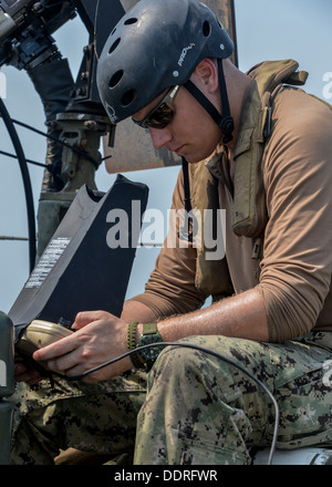 ARABIAN GULF (Sept. 3, 2013) Electronics Technician 3rd Class Mitch Marema, assigned to Commander, Task Group 56.7.4, Coastal Riverine Squadron 4, remotely controls a Puma AE unmanned aerial vehicle, aboard a Riverine Command Boat (RCB), at-sea. RCBs prov Stock Photo