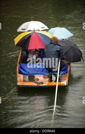 Tourists punting on the river Cam in Cambridge in the rain
