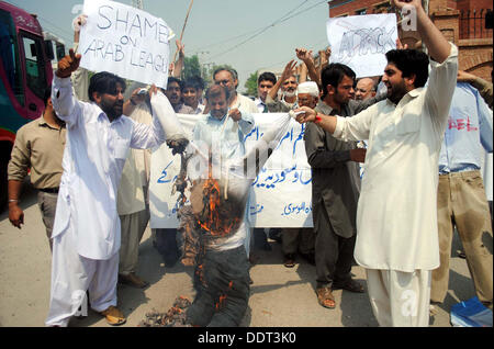 Activists of Tehreek Nifaaz Fiqah Jafferia (TNFJ) burn effigy and flags of US and Israel as they are protesting against US Government during demonstration at Peshawar press club on Friday, September 06, 2013. Stock Photo