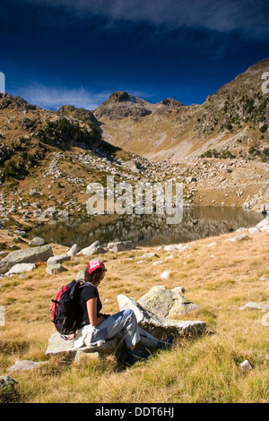 Woman hiker close to a mountain lake. Stock Photo