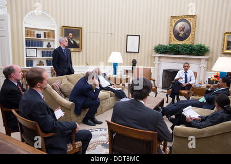 President Barack Obama meets with senior advisors in the Oval Office to discuss a new plan for the situation in Syria, Friday night, August 30, 2013. Stock Photo