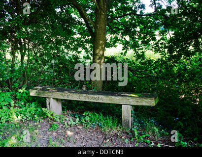 A wooden seat for rest on the Marriott's Way long distance footpath at Lenwade, Norfolk, England, United Kingdom. Stock Photo