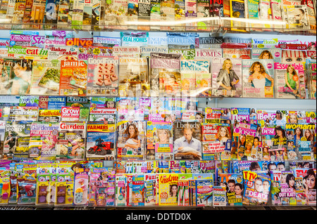 Magazines for sale on a shelf in a newsagent shop store in the Uk Stock Photo