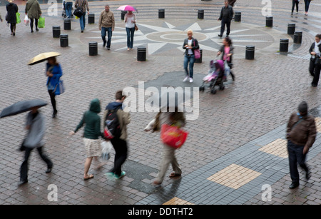 Shoppers crossing Queens Square pavement in the rain, Liverpool, Merseyside, UK Stock Photo