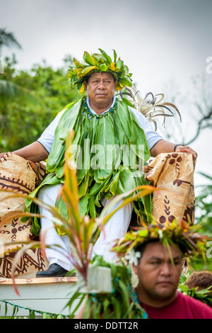 COOK ISLANDS - Makirau Haurua in traditional costume being carried on throne during investiture - Aitutaki, South Pacific Stock Photo