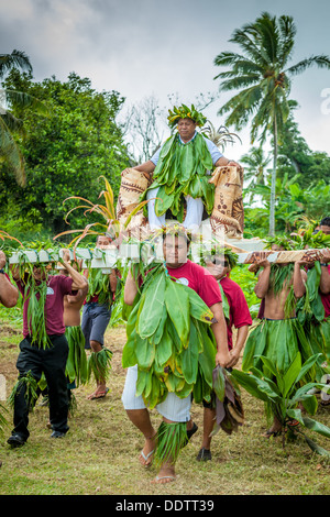 COOK ISLANDS - Makirau Haurua in traditional costume being carried on throne during investiture - Aitutaki, South Pacific Stock Photo