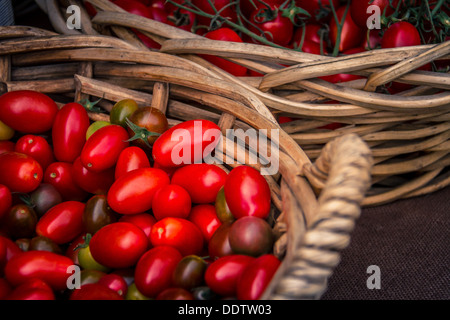 Two wicker baskets full of ripe organic fresh Roma tomatoes. Stock Photo