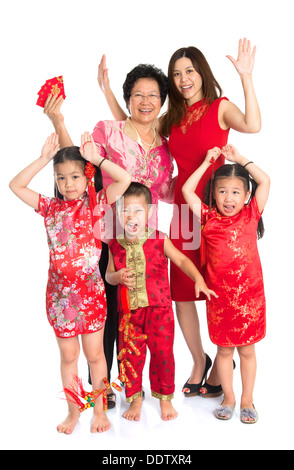 Group of happy smiling multi generations Asian Chinese family wishing you a happy Chinese New Year, with traditional Cheongsam standing isolated on white background. Stock Photo