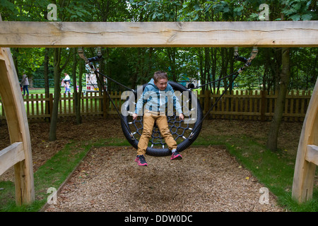 Young boy playing on the Wilderness Play Area at Witley Court and Gardens in Worcestershire. Stock Photo