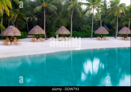 Umbrellas and chairs on lagoon beach. Bora Bora. French Polynesia. Stock Photo