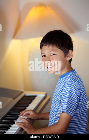 Yong boy plays on an electronic piano keyboard Stock Photo