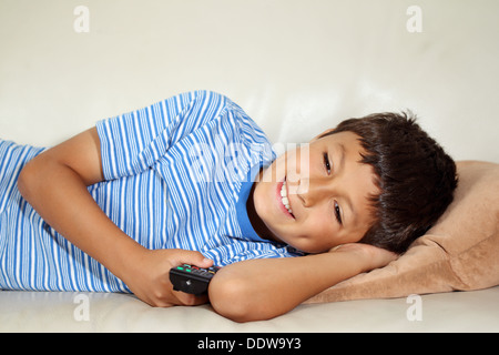 Young boy watching TV with remote control Stock Photo