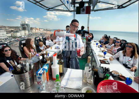 A British Airways Chef serves cocktail drinks to diners 100 foot high in the sky above Brighton and Hove beach Stock Photo