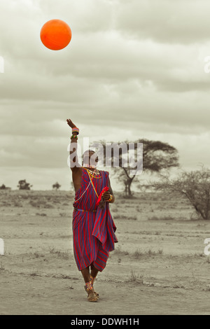 Maasai warrior dressed in traditional red clothes with rungu weapon in ...