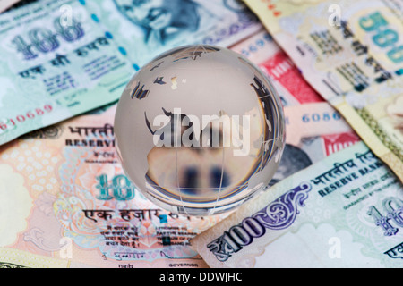 Crystal Glass globe showing India on Rupee notes Stock Photo