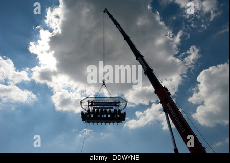 A  British Airways high-flying dining table dangling from a crane with 22 diners 100 foot high in the sky above Brighton and Hove beach. Stock Photo