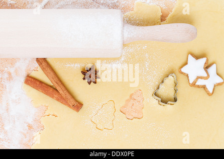 cutting out christmas shape cookies of dough from top Stock Photo