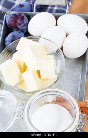 butter in a small glass bowl between baking ingredients on a metal tray Stock Photo