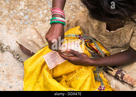 Indian street girl begging for money with 10 rupee notes in her hand Stock Photo