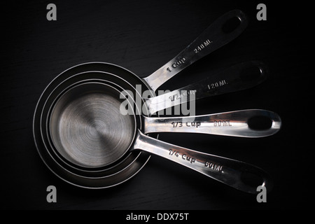 A set of kitchen measuring cups/spoons photographed against a black background. Stock Photo