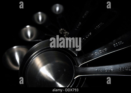 A set of kitchen measuring cups/spoons photographed against a black background. Stock Photo