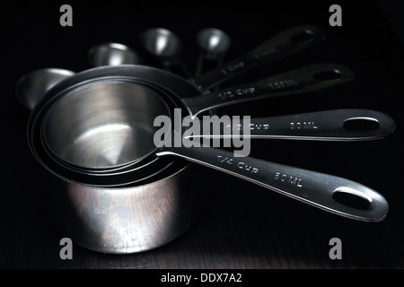 A set of kitchen measuring cups/spoons photographed against a black background. Stock Photo