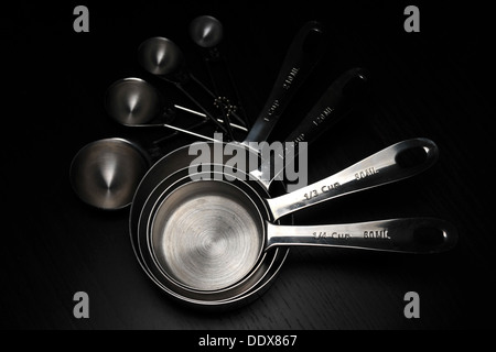 A set of kitchen measuring cups/spoons photographed against a black background. Stock Photo