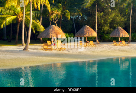 Unbrellas and chairs on lagoon beach. Bora Bora. French Polynesia. Stock Photo