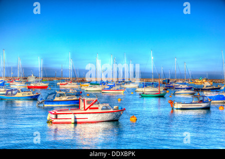 Colourful red blue and green boats and blue sea and sky in vibrant HDR Stock Photo