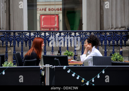 Two young women having drinks in an outdoor café in Glasgow, Scotland, UK, Europe Stock Photo