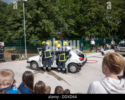 Fire crew demonstrating cutting a car roof in rescue simulation at a fire station open day Stock Photo
