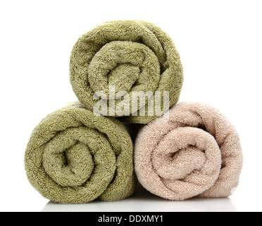 Three rolled bath towels freshly laundered on a white background with reflection. Closeup looking at the towel ends. Stock Photo