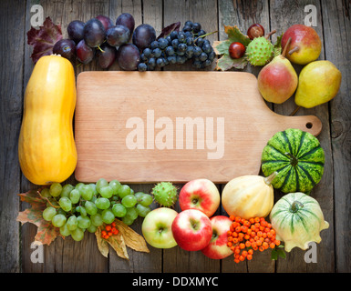 Autumn fruits and vegetables and empty cutting board background Stock Photo