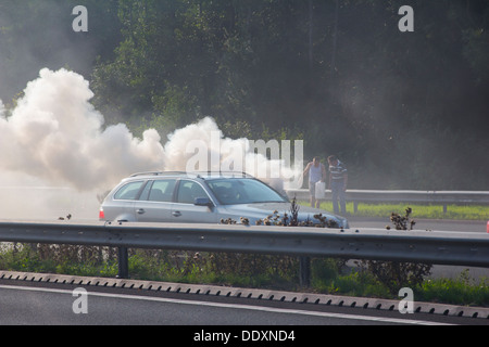 A car on fire on the Eastbound carriageway of the M4 approaching Newport. Stock Photo