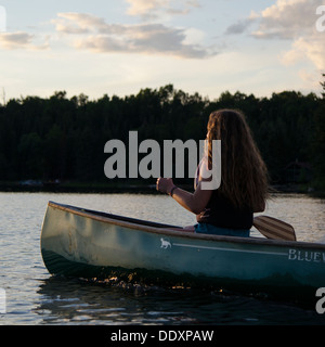 Girl rowing a boat in a lake, Lake of The Woods, Keewatin, Ontario, Canada Stock Photo