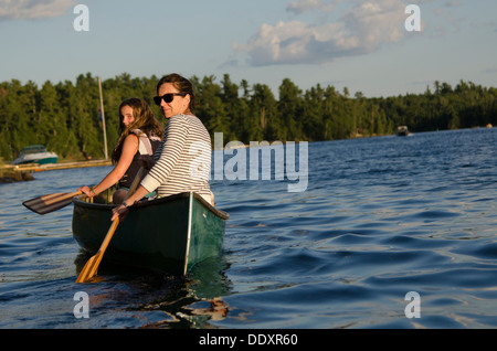 Woman rowing a canoe with her daughter, Lake of The Woods, Keewatin, Ontario, Canada Stock Photo