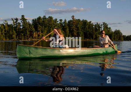 Woman rowing a canoe with her daughter, Lake of The Woods, Keewatin, Ontario, Canada Stock Photo