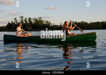 Woman rowing a boat with her daughter, Lake of The Woods, Keewatin, Ontario, Canada Stock Photo