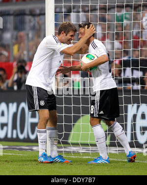 Germanys Thomas Muller (L) celebrates scoring the 3:0 with Mesut Ozil during the soccer match for the qualification of the world cup between Germany and Autria, Allianz Arena in Munich on September 06. 2013. Stock Photo