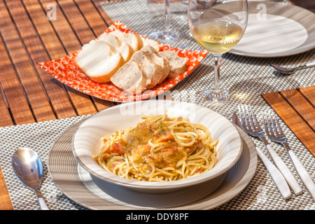 Spaghetti with tomato and pesto sauce in a teak wood table Stock Photo