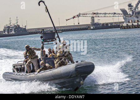 U.S. Marines assigned to Force Reconnaissance Platoon, Maritime Raid Force, 26th Marine Expeditionary Unit provide security as they approach a vessel during training August 28, 2013 in Bahrain. Stock Photo