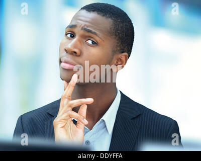 Young businessman, African-American, American, respectable, pensive face, focused, at the office Stock Photo