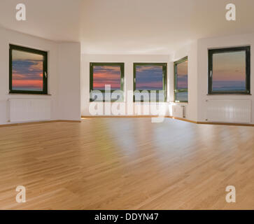 Large living room with 5 windows and light parquet flooring, sunset sky, compositing, rental apartment, real estate Stock Photo