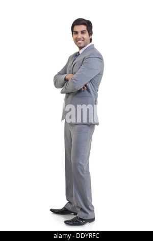Full length portrait of young businessman with arms crossed standing ...