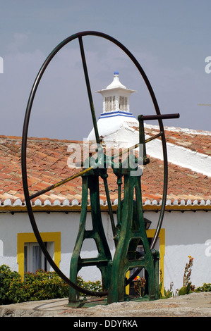 An old iron hand pump waterwheel to draw water in Cacela Velha village located in the civil parish of Vila Nova de Cacela, municipality of Vila Real de Santo Antonio, in Algarve the southernmost region of Portugal Stock Photo