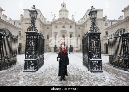 Household Cavalry trooper from the Blues and Royals (Royal Horse Guards and 1st Dragoons) Regiment, standing guard outside of Horse Guards Parade in the snow, London, England Stock Photo