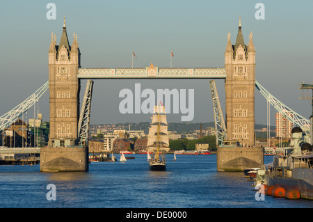 Tall sailing ship Mercedes passing underneath a raised Tower Bridge, on the river Thames, London England Stock Photo
