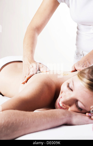 Young woman having her back massaged by a therapist Stock Photo